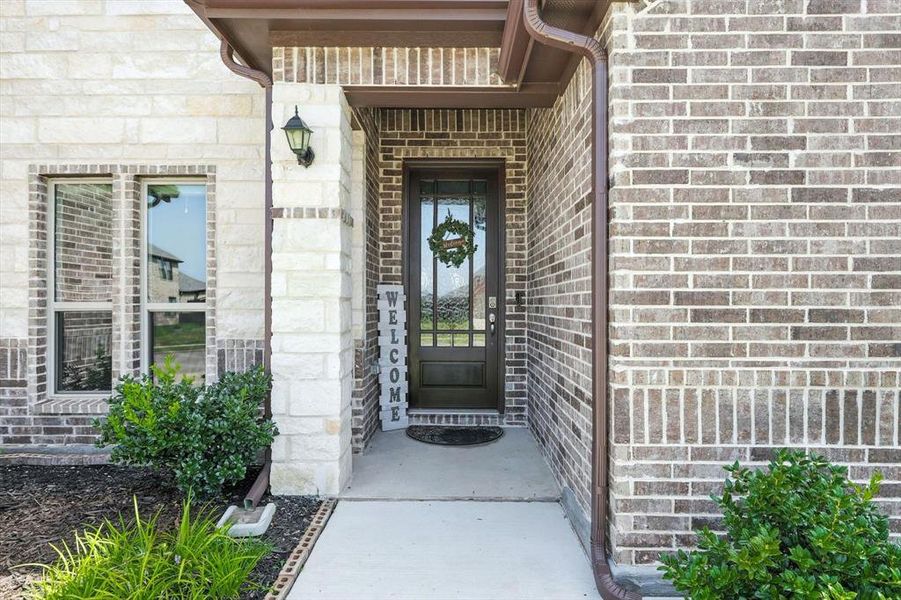 Entrance to property with brick siding and stone siding