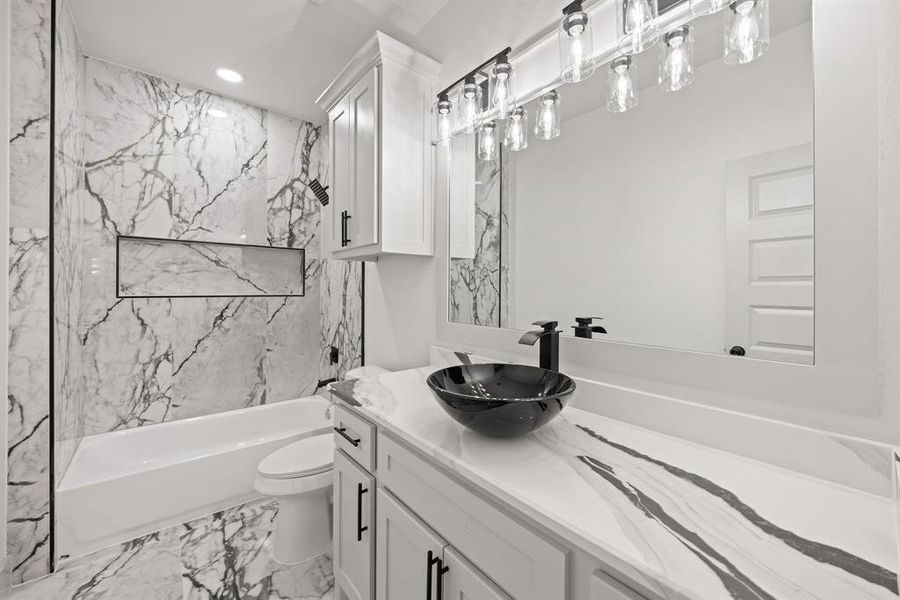 Full bath with vanity, light marble finish flooring, a combined bath / shower with marble appearance, and recessed lighting Full bath with vanity, light marble finish flooring, a combined bath / shower with marble appearance, and recessed lighting
