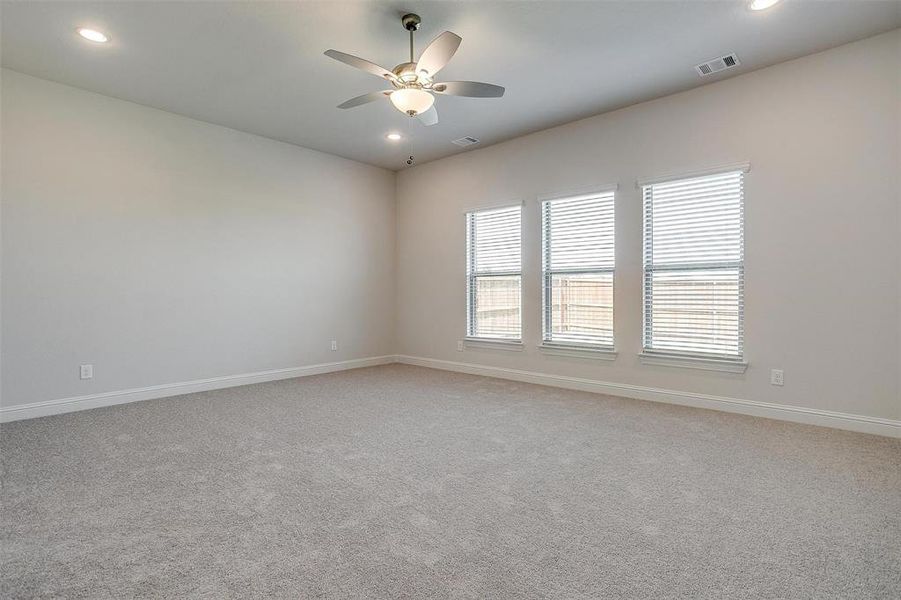 Carpeted spare room with ceiling fan