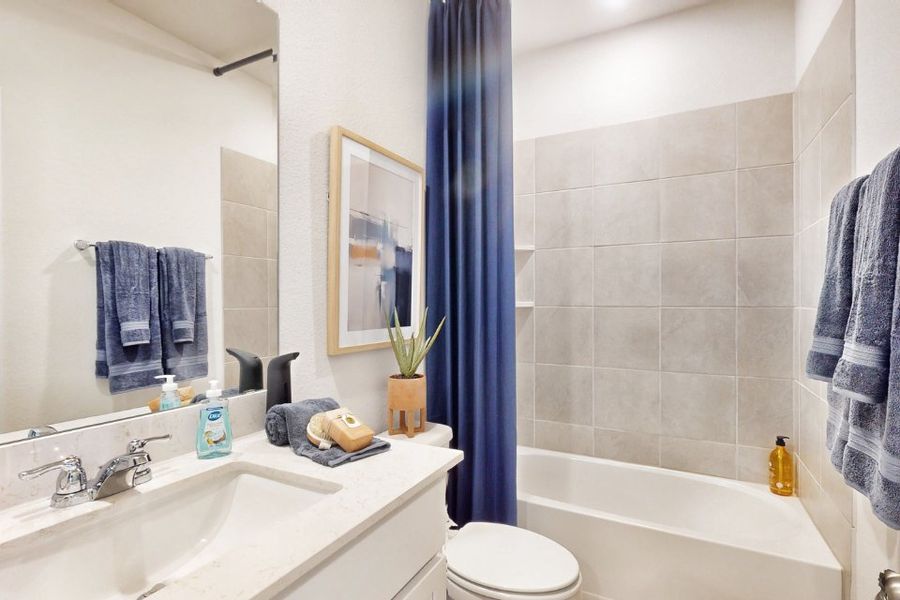 A bathroom with a blue shower curtain.