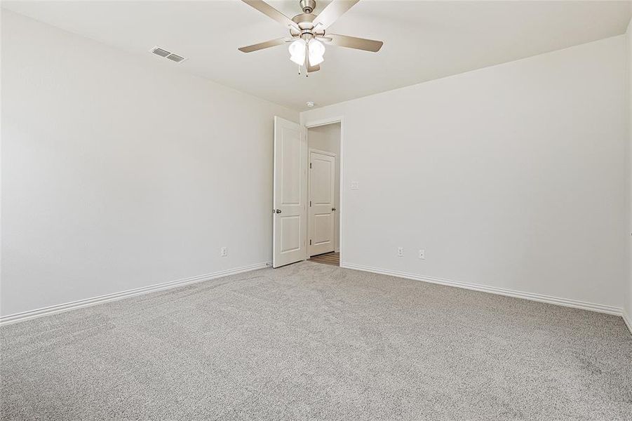 Spare room featuring light colored carpet and ceiling fan