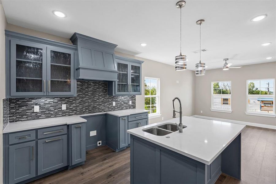 Kitchen with backsplash, decorative light fixtures, dark wood finished floors, glass insert cabinets, and recessed lighting Kitchen with backsplash, decorative light fixtures, dark wood finished floors, glass insert cabinets, and recessed lighting