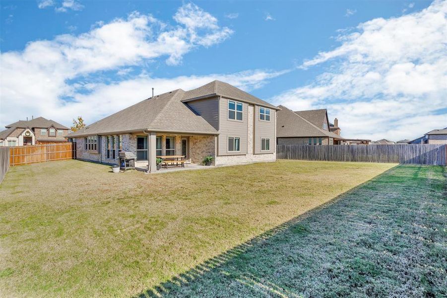 Rear view of house with a yard and a patio