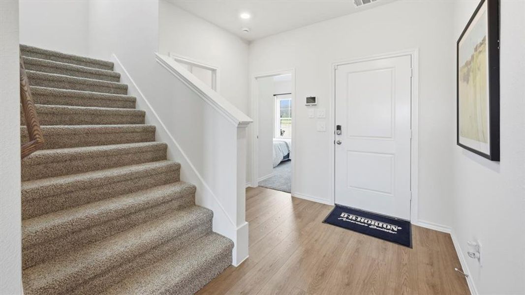 Entryway with light wood finished floors and recessed lighting Entryway with light wood finished floors and recessed lighting