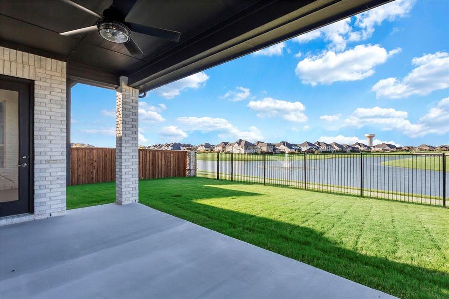 Fenced backyard featuring a water view, ceiling fan, a patio area, and a residential view