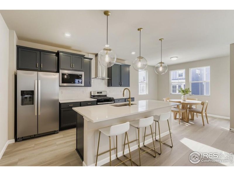 Sleek modern features such as a gas range, vented hood, quartz countertops and included refrigerator