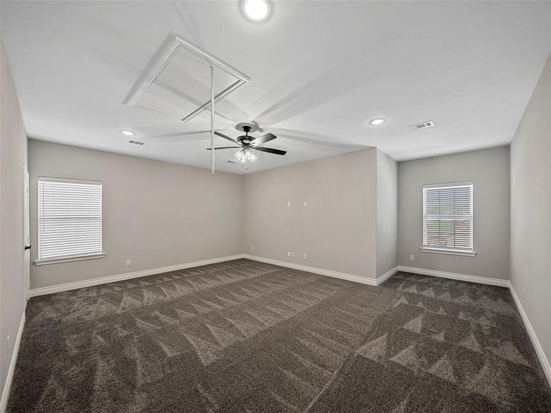 Unfurnished room featuring attic access, dark carpet, recessed lighting, and a ceiling fan Unfurnished room featuring attic access, dark carpet, recessed lighting, and a ceiling fan