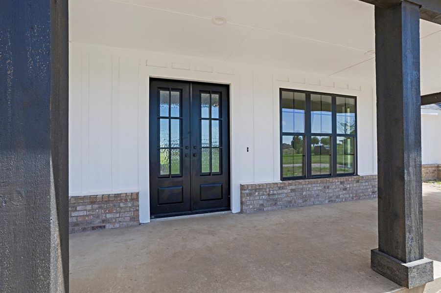 View of exterior entry with french doors and brick siding