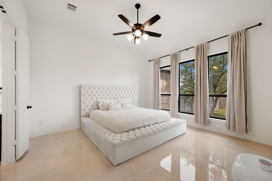 Natural light floods this spacious bedroom, highlighting polished flooring and an elegant tufted bed. Natural light floods this spacious bedroom, highlighting polished flooring and an elegant tufted bed.