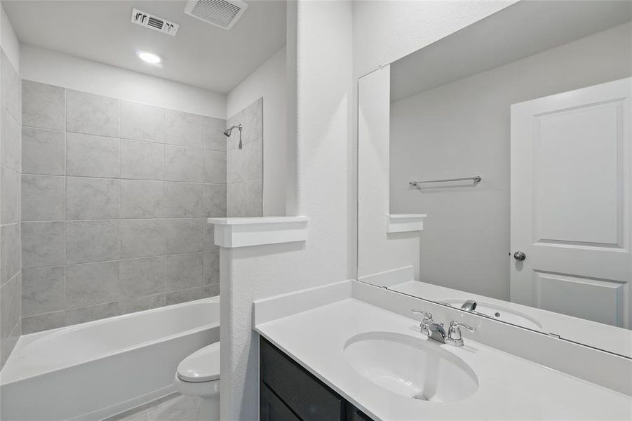 Bathroom featuring vanity and washtub / shower combination