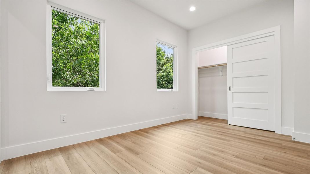 Unfurnished bedroom with recessed lighting, light wood-type flooring, and a closet Unfurnished bedroom with recessed lighting, light wood-type flooring, and a closet