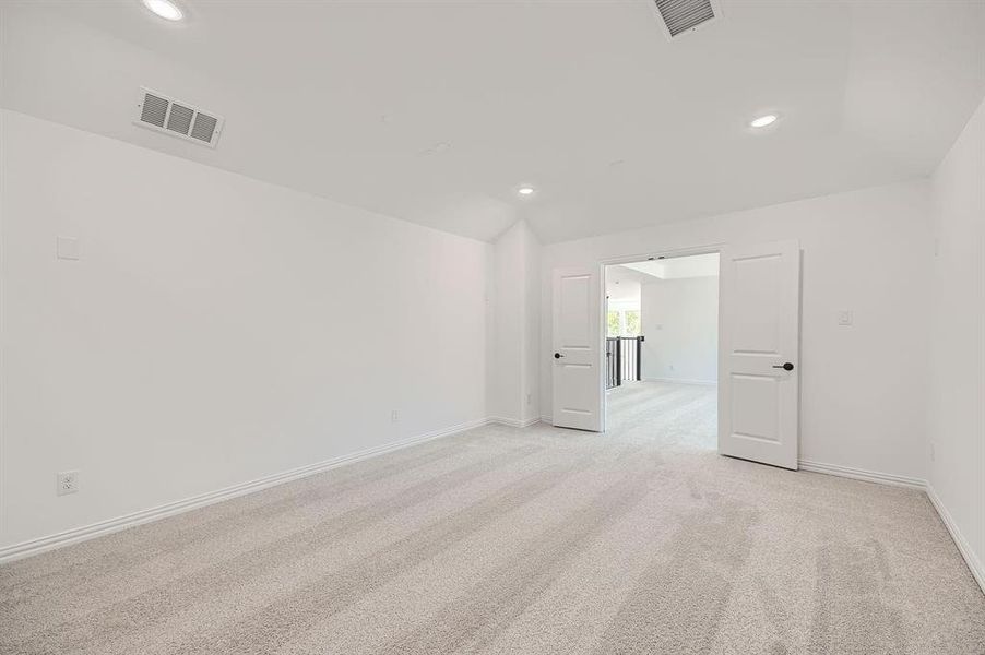 Spacious room featuring light-toned carpeting, crisp white walls, recessed ceiling lighting, and double-door entry Spacious room featuring light-toned carpeting, crisp white walls, recessed ceiling lighting, and double-door entry