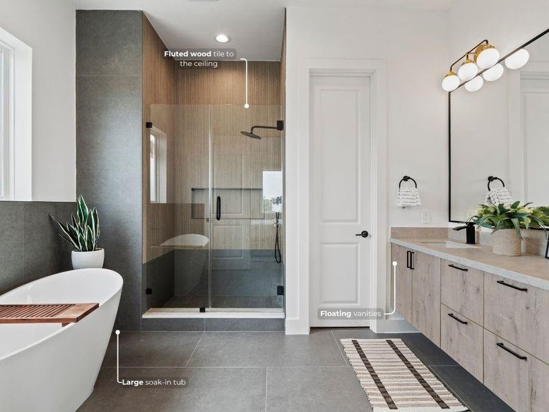 Step into your spacious ensuite bath featuring floating dual vanities with generous storage, a deep soaking tub, and a frameless glass shower accented with modern fluted tile.