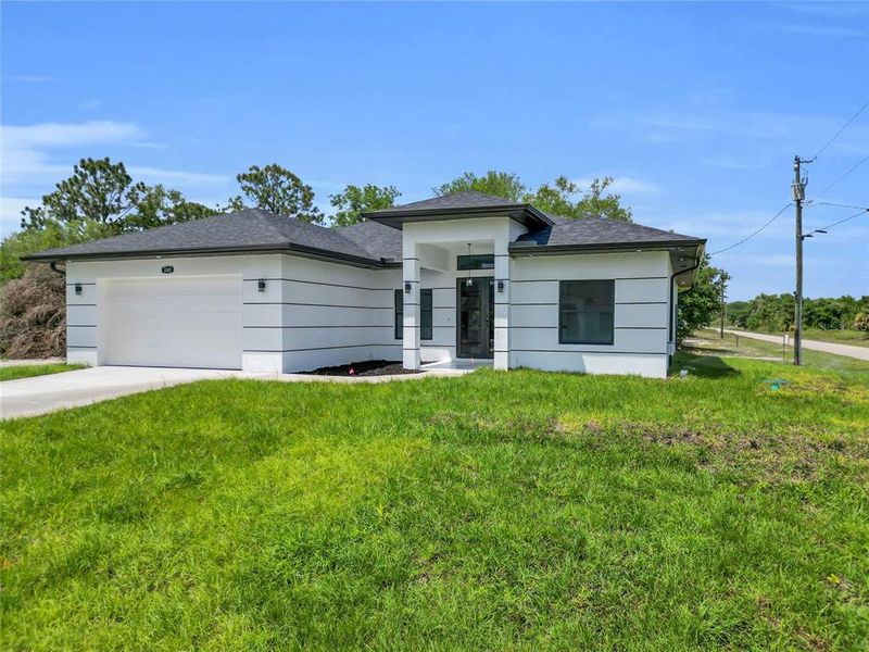 Front exterior of a new home in , Lehigh Acres, FL, highlighting curb appeal (Image 16).