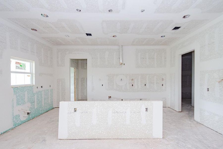 Spacious unfinished kitchen and kitchen island area with drywall in place, offering a blank canvas for customization and design. Spacious unfinished kitchen and kitchen island area with drywall in place, offering a blank canvas for customization and design.
