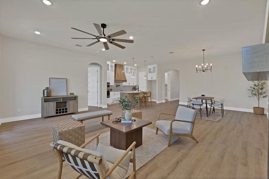 Living room with arched walkways, baseboards, a chandelier, light wood-style flooring, and recessed lighting Living room with arched walkways, baseboards, a chandelier, light wood-style flooring, and recessed lighting