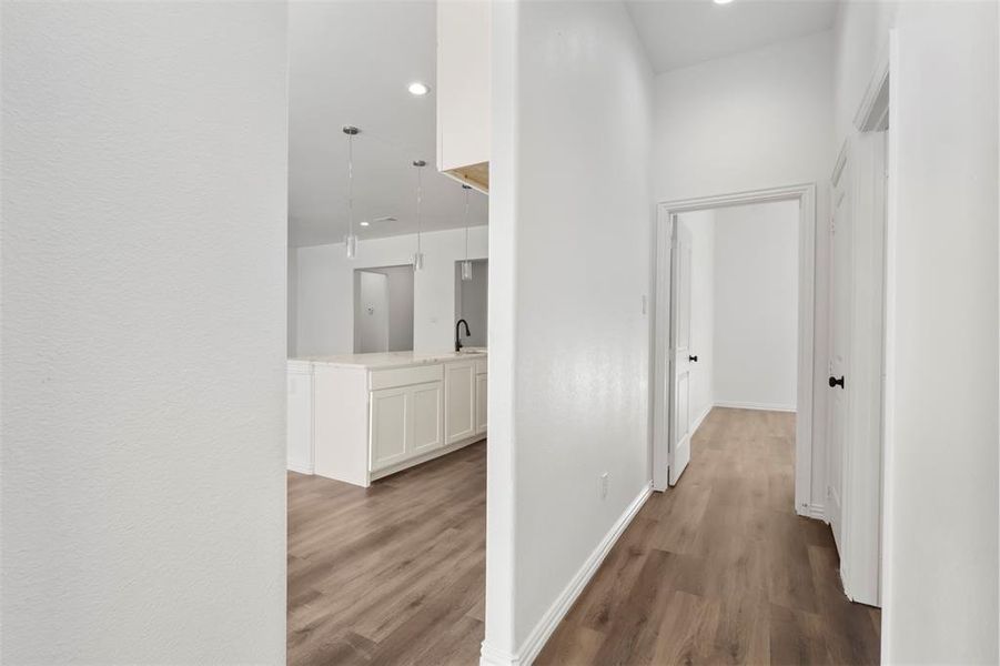 Hall with a high ceiling, hardwood / wood-style flooring, and sink