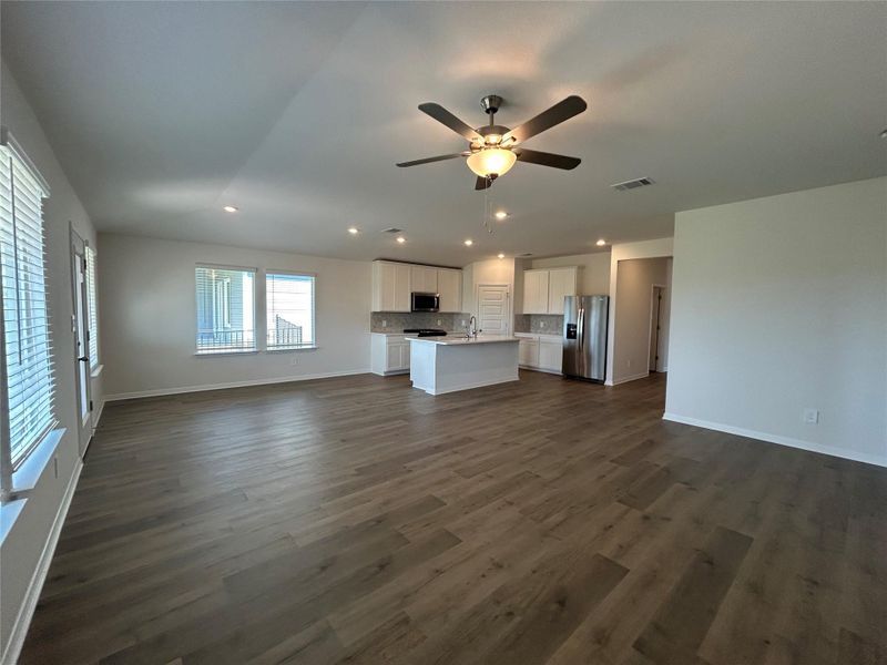 Unfurnished living room with recessed lighting, ceiling fan, and dark wood-style flooring Unfurnished living room with recessed lighting, ceiling fan, and dark wood-style flooring