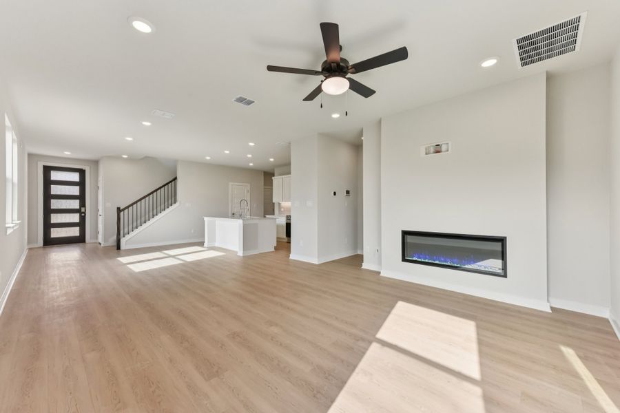 A room with a wood floor and a wood floor with a ceiling fan. A room with a wood floor and a wood floor with a ceiling fan.