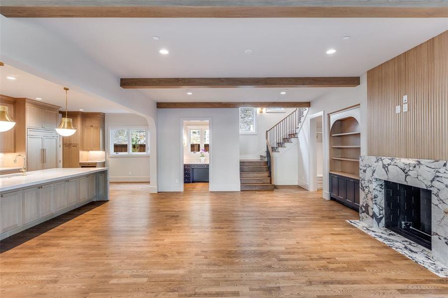 Unfurnished living room featuring recessed lighting, a fireplace, light wood-style flooring, stairs, and beam ceiling Unfurnished living room featuring recessed lighting, a fireplace, light wood-style flooring, stairs, and beam ceiling