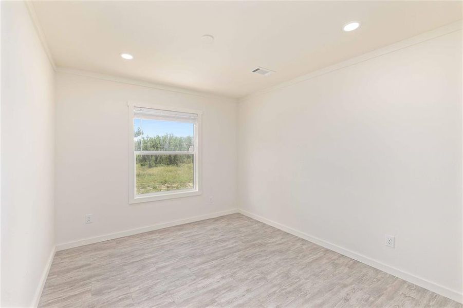 Room featuring light wood-finish flooring, recessed lighting, white walls, and a white-trimmed window