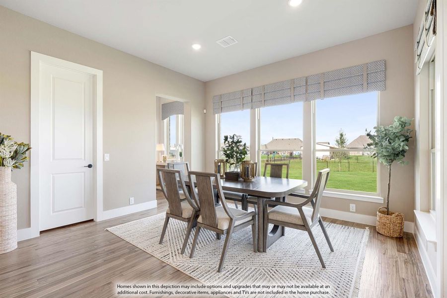 Dining room with dark wood table, six chairs, hardwood floors, and large windows overlooking a backyard
