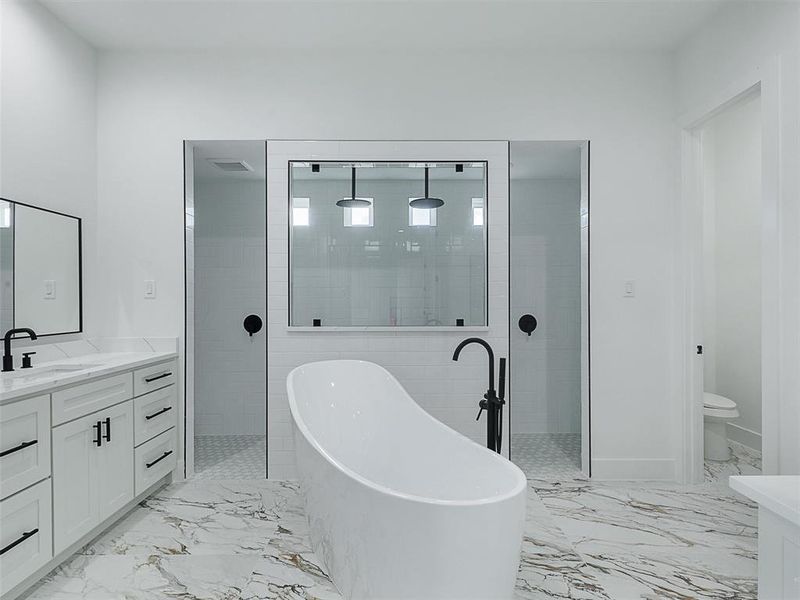 The luxurious primary suite serves as a tranquil retreat, featuring a spa-like bathroom with a Roman shower.