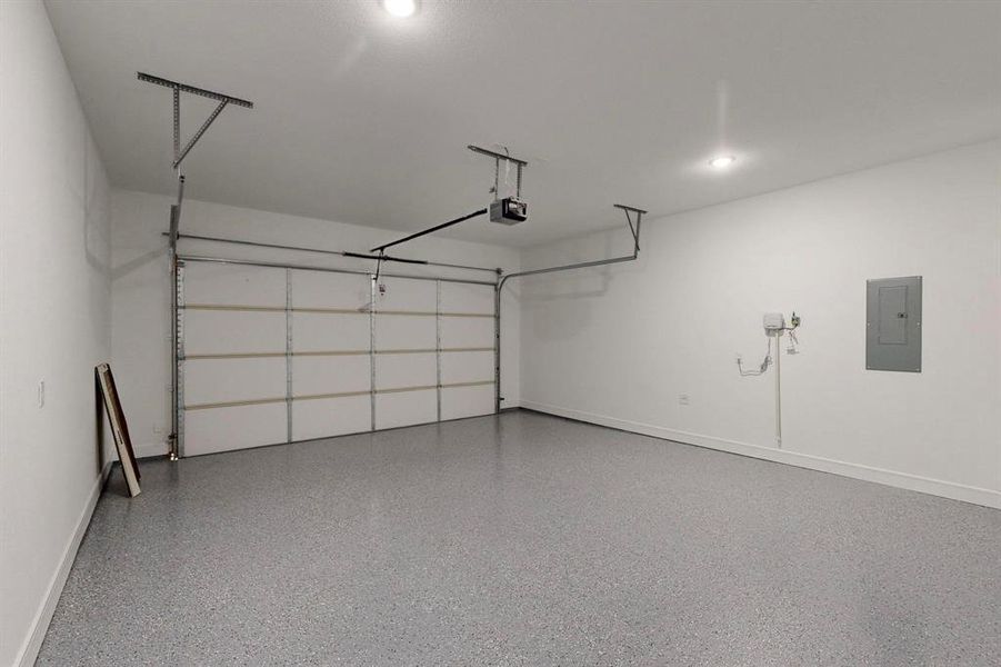 Garage featuring electric panel and a garage door opener