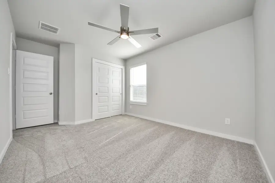 Generously sized secondary bedrooms featuring spacious closets, soft and inviting carpeting underfoot, large windows allowing plenty of natural light, and the added touch of privacy blinds for your personal retreat. Sample photo of completed home with similar floor plan. Actual colors and selections may vary.
