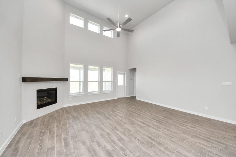 Gather the family and guests together in your lovely living room! Featuring soaring high ceilings, recessed lighting, ceiling fan, custom paint, gorgeous floors, and large windows that provide plenty of natural lighting throughout the day. Gather the family and guests together in your lovely living room! Featuring soaring high ceilings, recessed lighting, ceiling fan, custom paint, gorgeous floors, and large windows that provide plenty of natural lighting throughout the day.