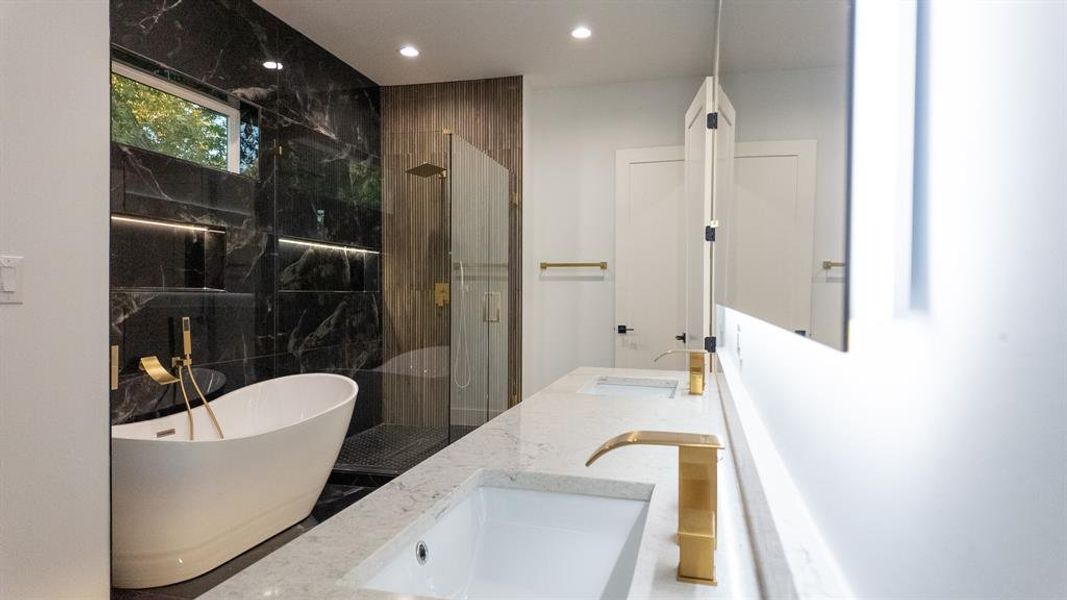 Full bathroom with a marble finish shower, a freestanding bath, double vanity, and recessed lighting