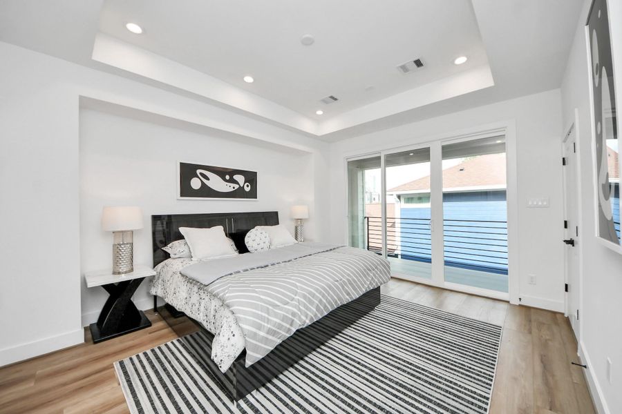 Experience luxurious comfort in this bright, second-floor primary bedroom, featuring sleek modern design and a private balcony.