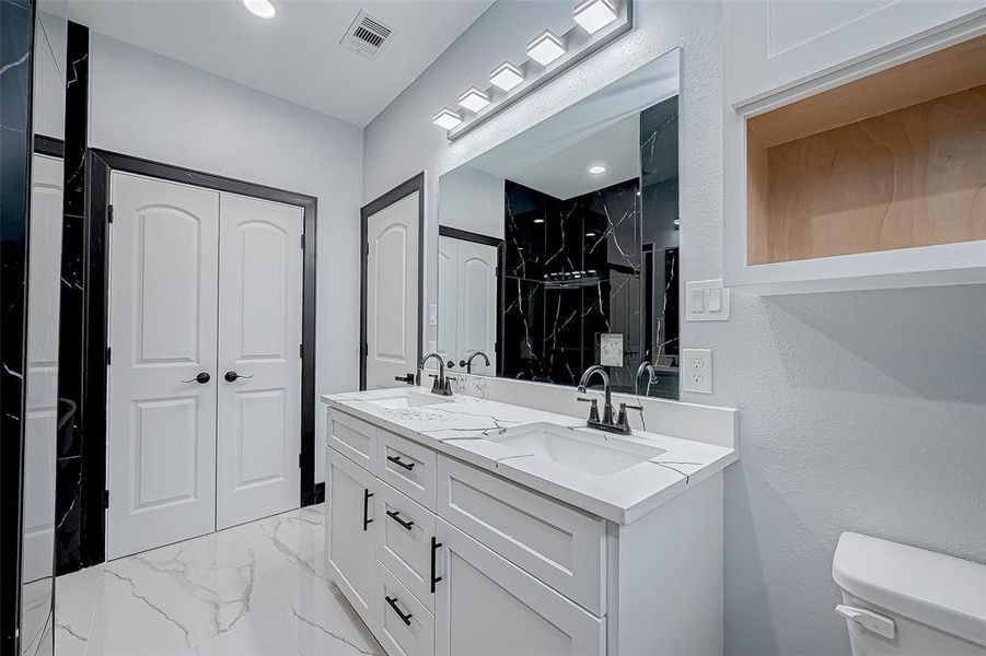 The primary bathroom features double sinks and quartz countertops for added style.