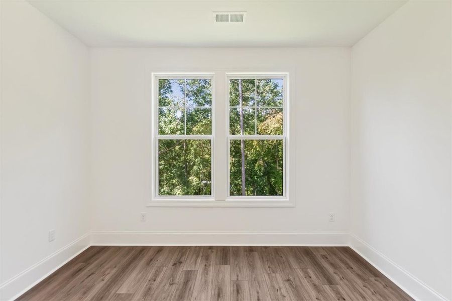 Rich wood-look flooring and a double window lookin