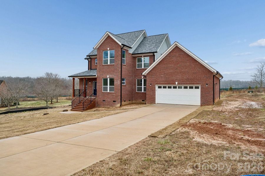 Exterior front offers 3 sides brick, extensive concrete driveway for parking and an amazing covered front porch that features rout-iron railing and cedar columns