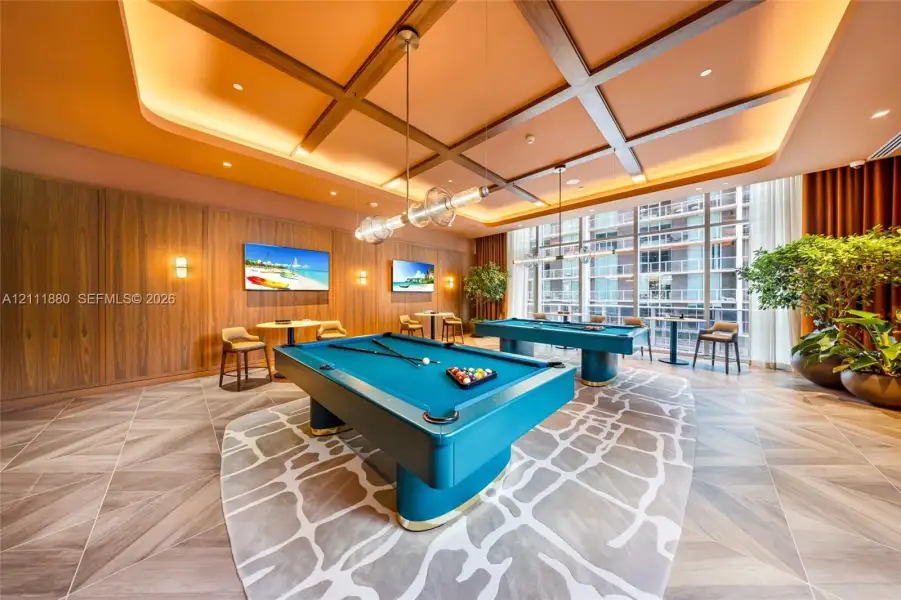 Coffered ceiling featuring recessed lighting, floor-to-ceiling glass windows, wood-paneled walls, and geometric wood-finish flooring