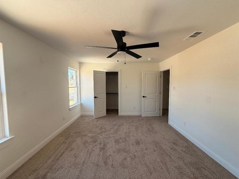 Unfurnished bedroom with carpet flooring, ceiling fan, and a closet