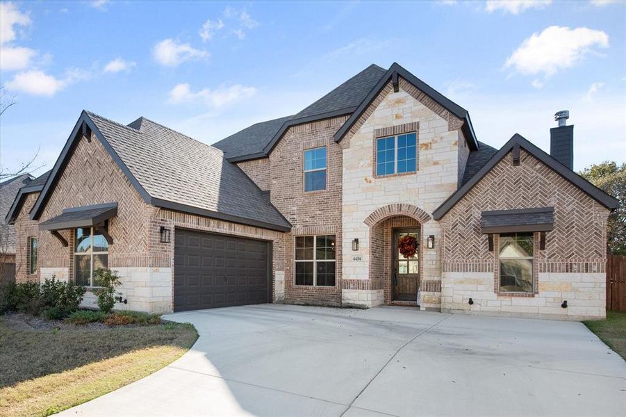 French country inspired facade with stone siding, driveway, brick siding, a chimney, and a shingled roof French country inspired facade with stone siding, driveway, brick siding, a chimney, and a shingled roof