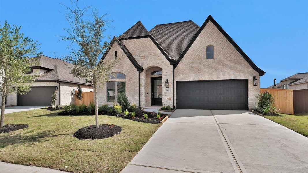 Front exterior of a new home in Meridiana, Manvel, TX, highlighting curb appeal (Image 2).