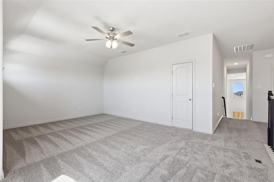 Carpeted room with a ceiling fan, white walls, and a two-panel interior door