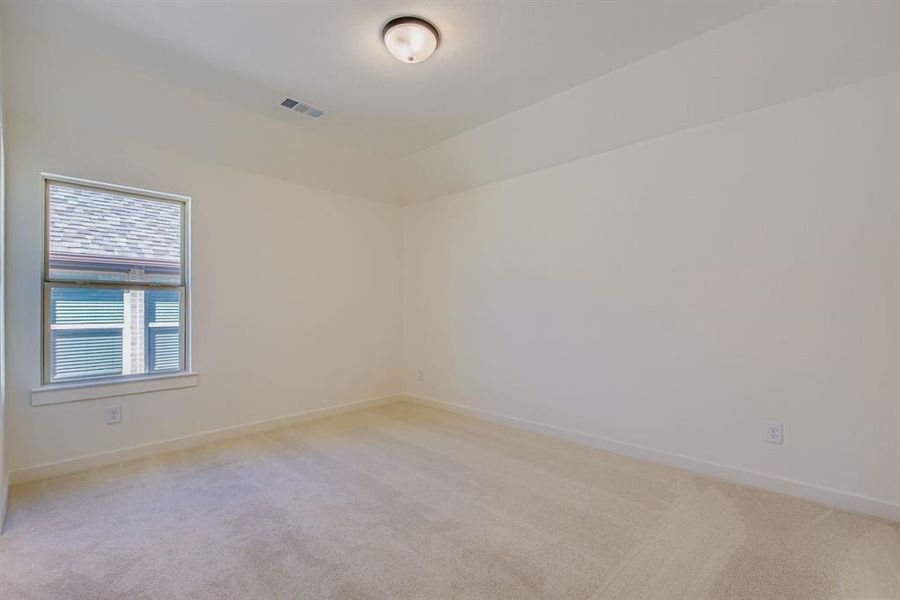 Empty room featuring light colored carpet
