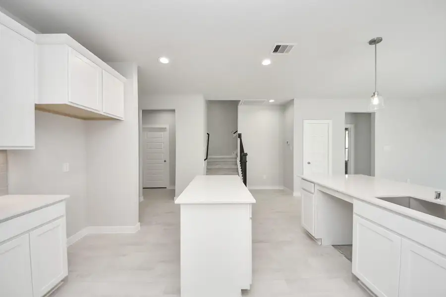 Culinary haven, featuring granite countertops, a tile backsplash, stainless steel appliances (to be installed), and 42” upper cabinets. Sample photo of completed home with similar floor plan. Actual colors and selections may vary.