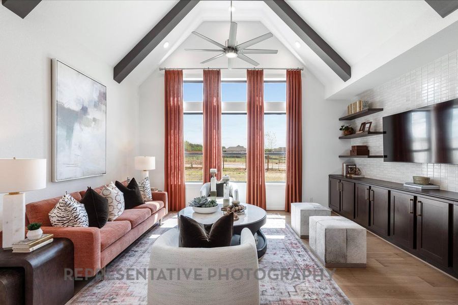 Living area featuring beamed ceiling, a ceiling fan, light wood finished floors, recessed lighting, and high vaulted ceiling