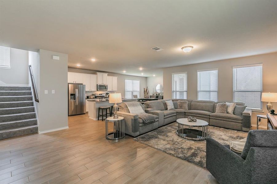 Living room featuring stairway, light wood-style flooring, and recessed lighting