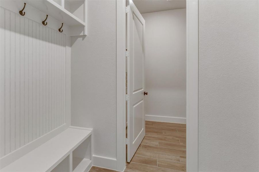 Built-in mudroom bench with cubby storage, beadboard paneling, and upper shelving with coat hooks Built-in mudroom bench with cubby storage, beadboard paneling, and upper shelving with coat hooks