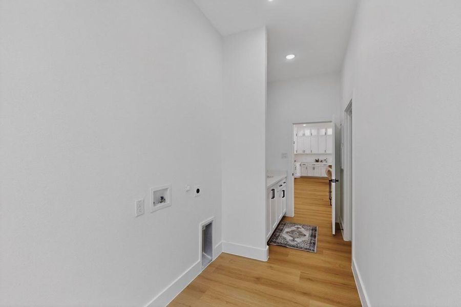 Washroom with electric dryer hookup, light wood finished floors, hookup for a washing machine, and recessed lighting
