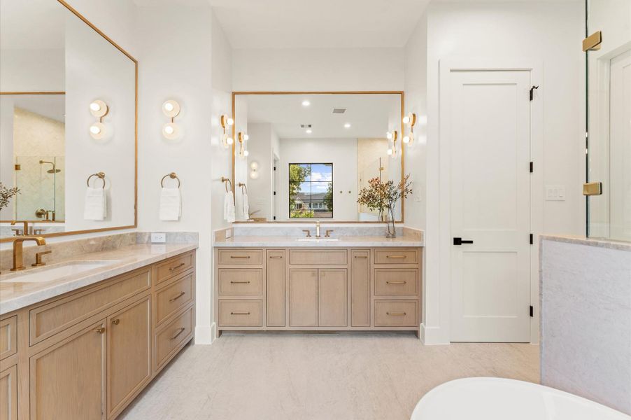 Custom inset white oak vanity cabinets are enhanced by Taj Mahal quartzite countertops. Custom inset white oak vanity cabinets are enhanced by Taj Mahal quartzite countertops.