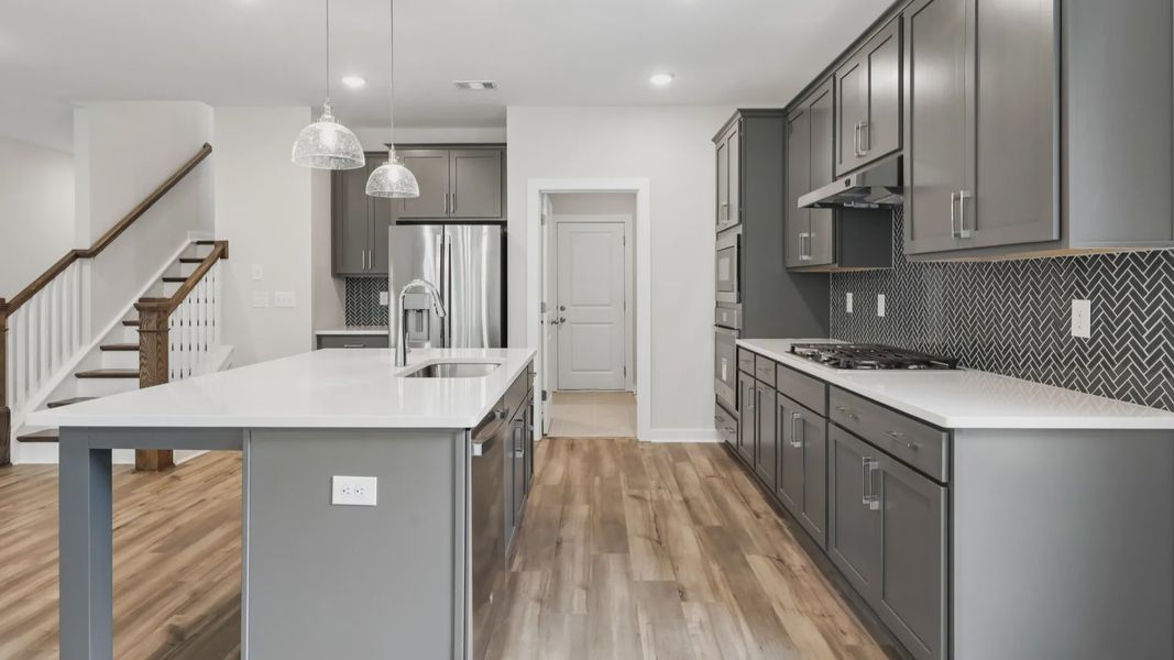 Kitchen with quartz countertops, pendant lighting, and hard surface flooring