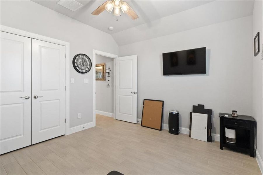 Living area with lofted ceiling, light wood-type flooring, a ceiling fan, and baseboards