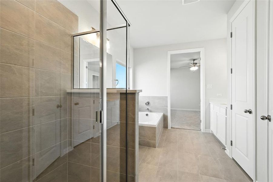 Full bathroom featuring a bath, a shower stall, light tile patterned floors, and vanity Full bathroom featuring a bath, a shower stall, light tile patterned floors, and vanity